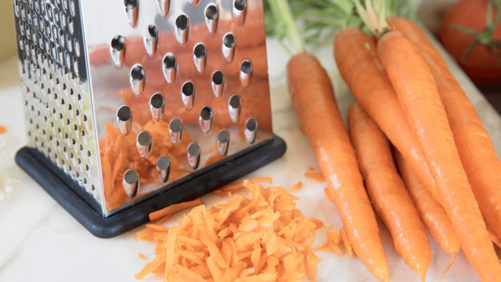Shred carrots using a box grater